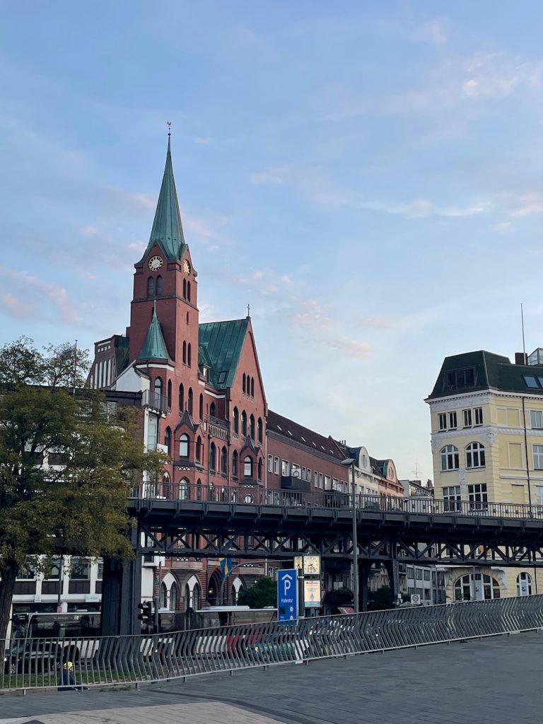 Die schwedische Kirche in Hamburg von der Promenade an den Landungsbrücken aus gesehen mit der Brücke der Hochbahn im Vordergrund